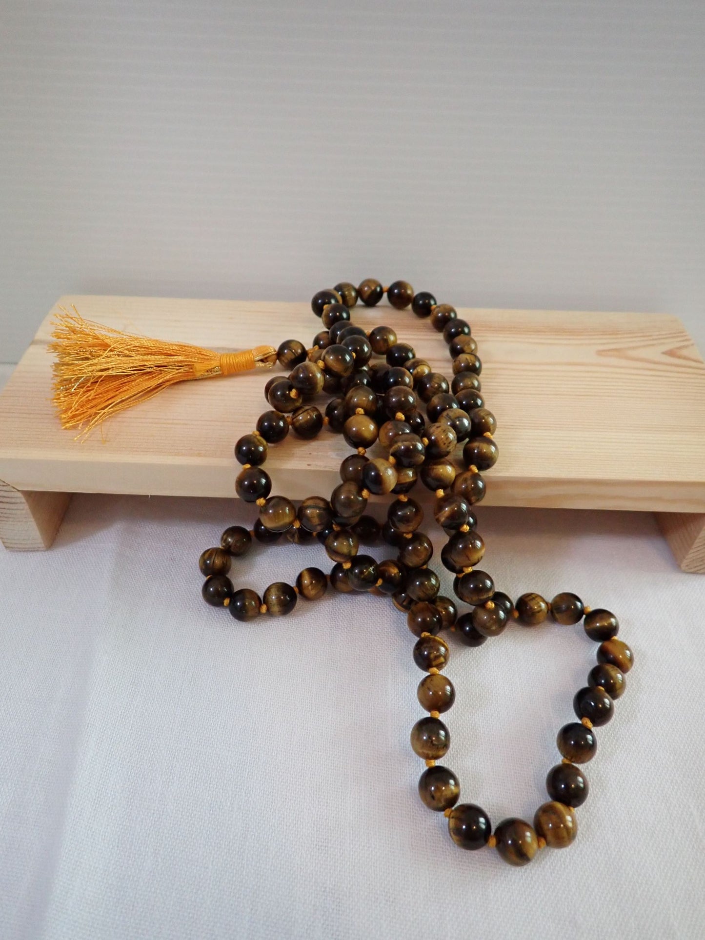 Tiger Eye Mala 108+1 beads displayed in shadow box frame